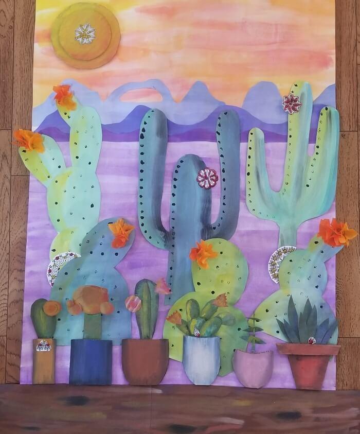 Succulents growing on a windowsill with mountains and a desert in the background