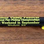 Black and Yellow pen with Walnut Valley Festival's "Fesity" logo and contact information