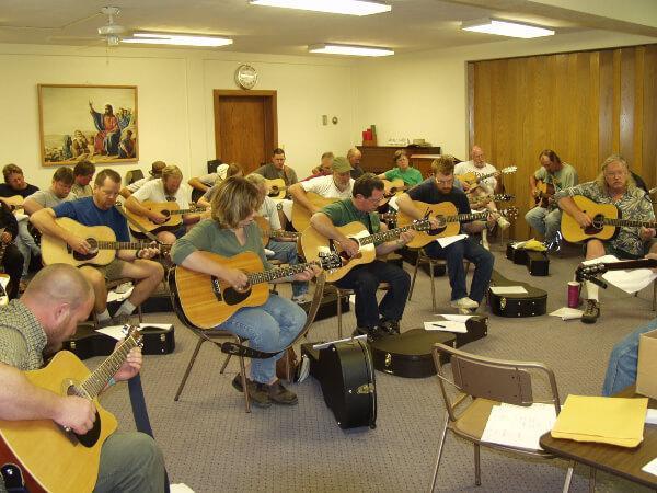 Group of students playing guitar during a workshop